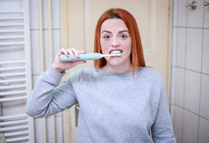 Kobieta myjąca zęby szczoteczką