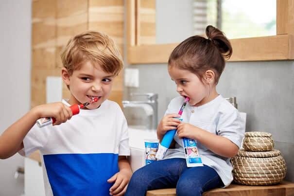 Dzieci myjące zęby szczoteczką elektryczną