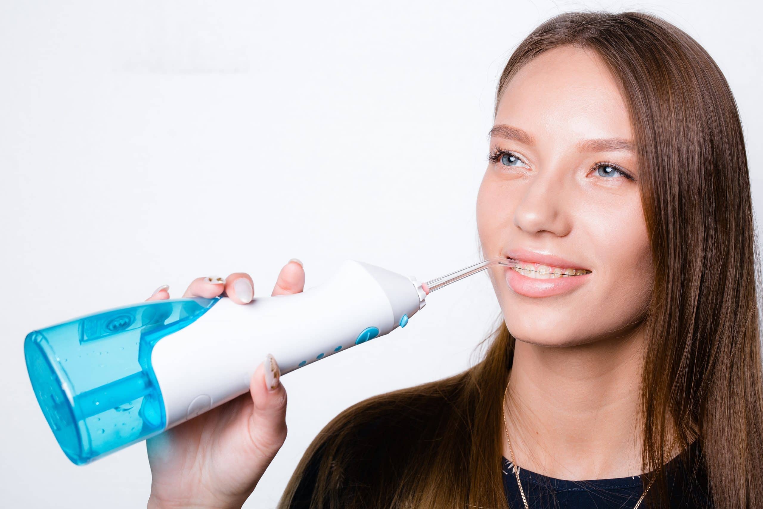 kobieta pokazuje jak używać irygatora do zębów