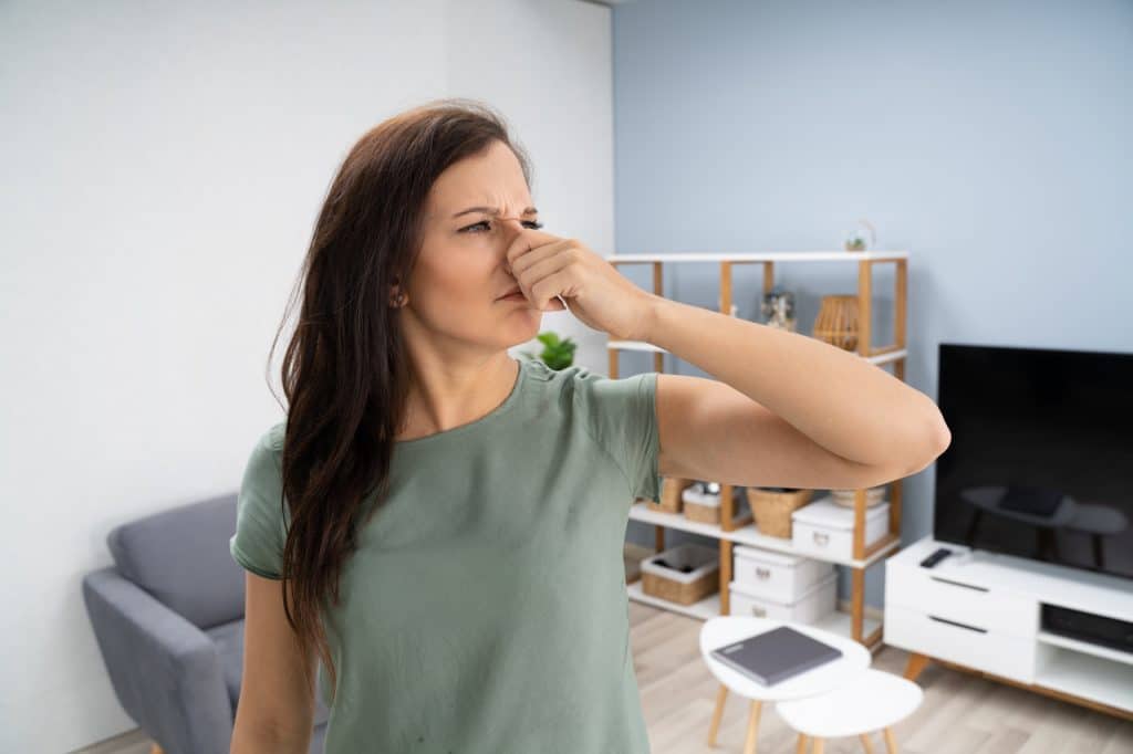 kobieta zatyka nos czując brzydki zapach