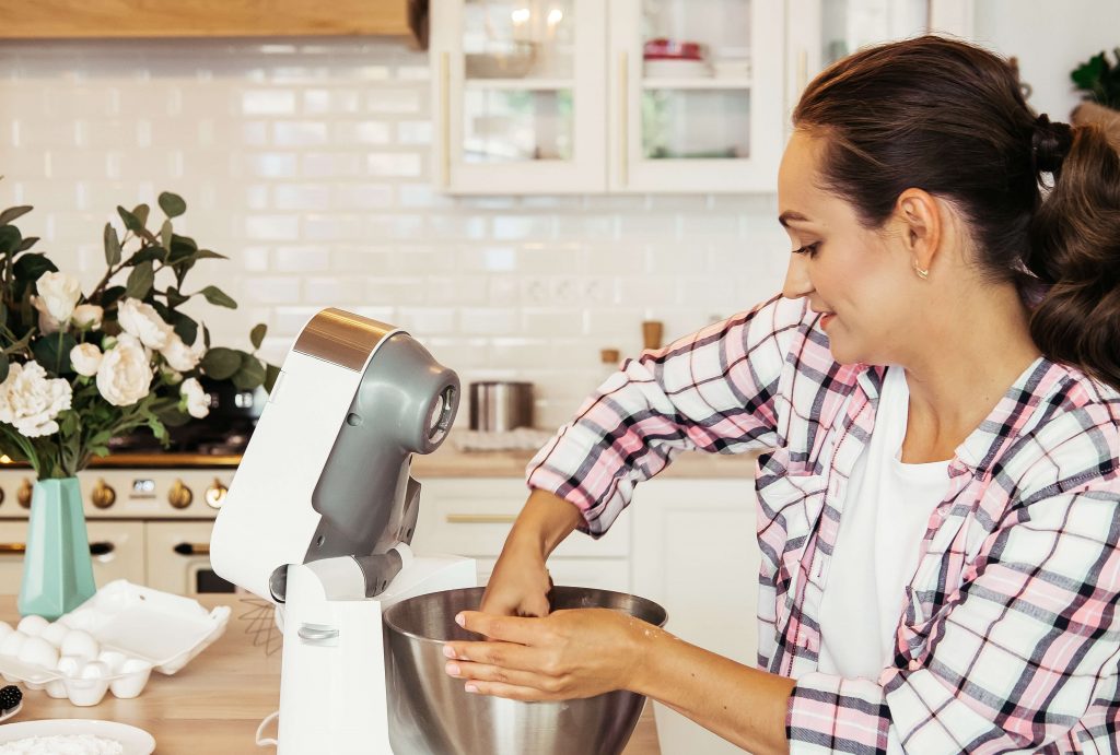 kobieta korzysta z robota kuchennego ze stalową miską