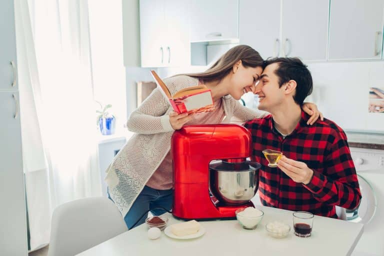 szczęśliwa para nad czerwonym robotem w kuchni