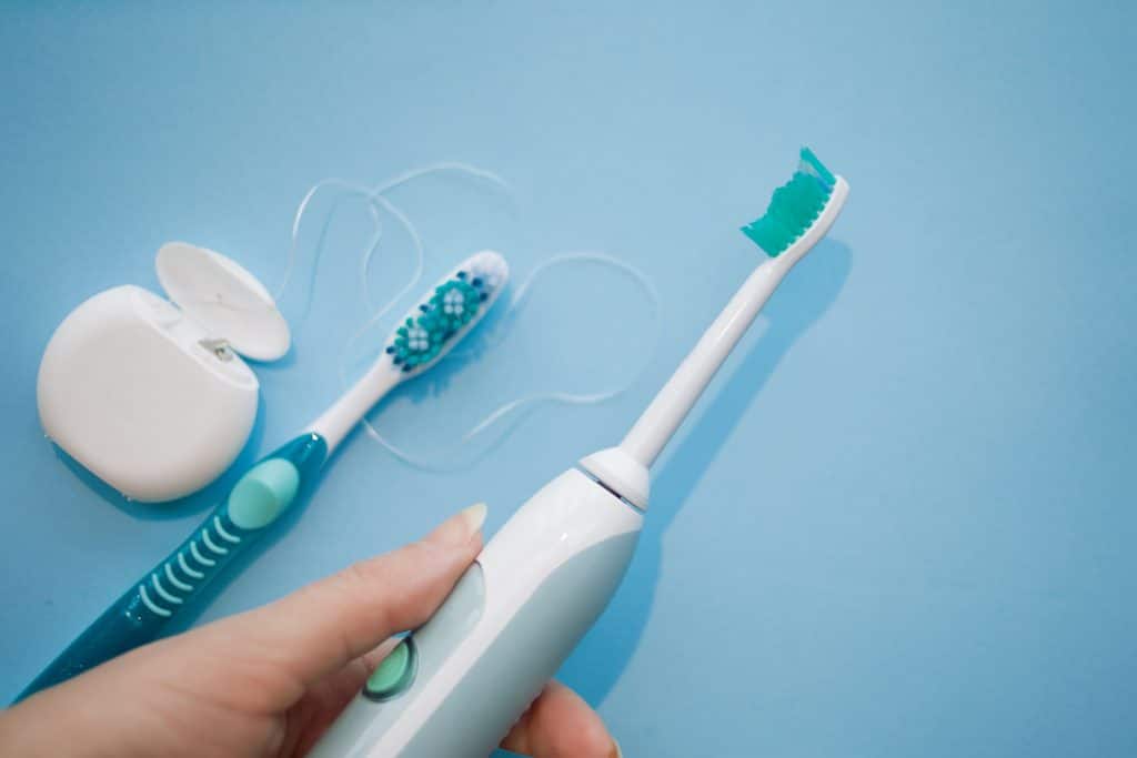 zestaw do czyszczenia aparatu ortodontycznego: szczoteczka soniczna i manualna, nić dentystyczna