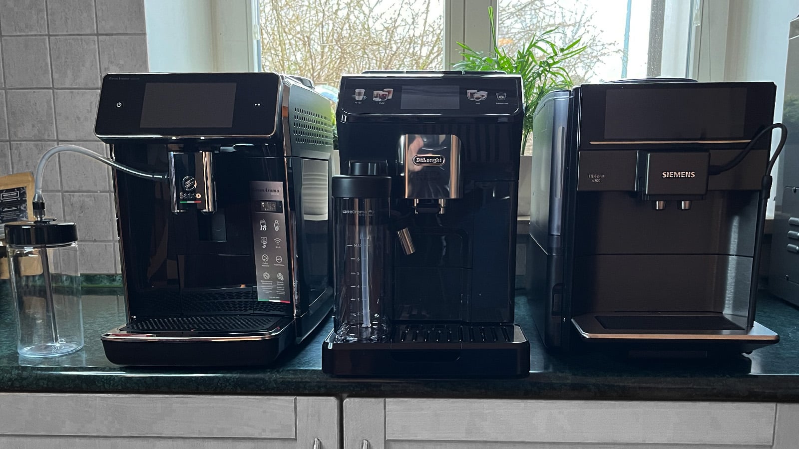 Trzy ekspresy do kawy: Siemens EQ.6 plus s 700 TE657319RW, De’Longhi Eletta Explore ECAM450.55.G i SaecoGranAroma Deluxe SM6680/00 stojące na blacie - zdjęcie.