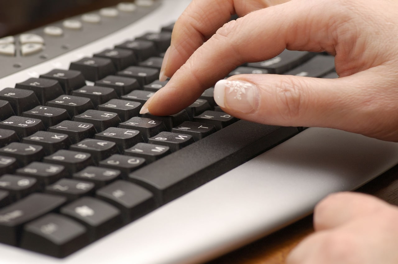 Kobiece dłonie piszące na klawiaturze mechanicznej wysokoprofilowej