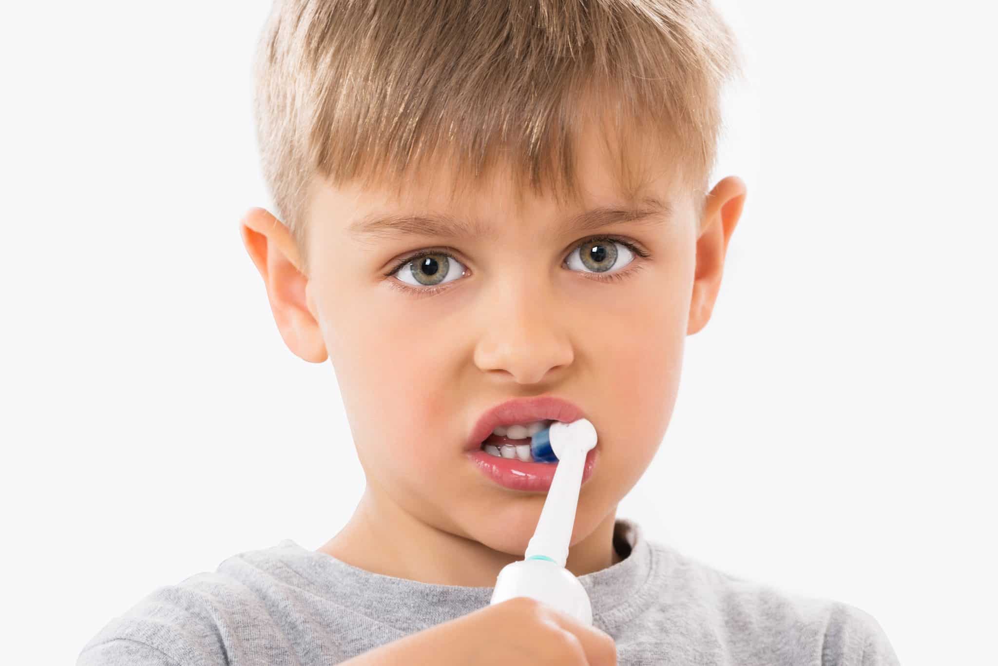 Chłopiec myjący zęby szczoteczką elektryczną