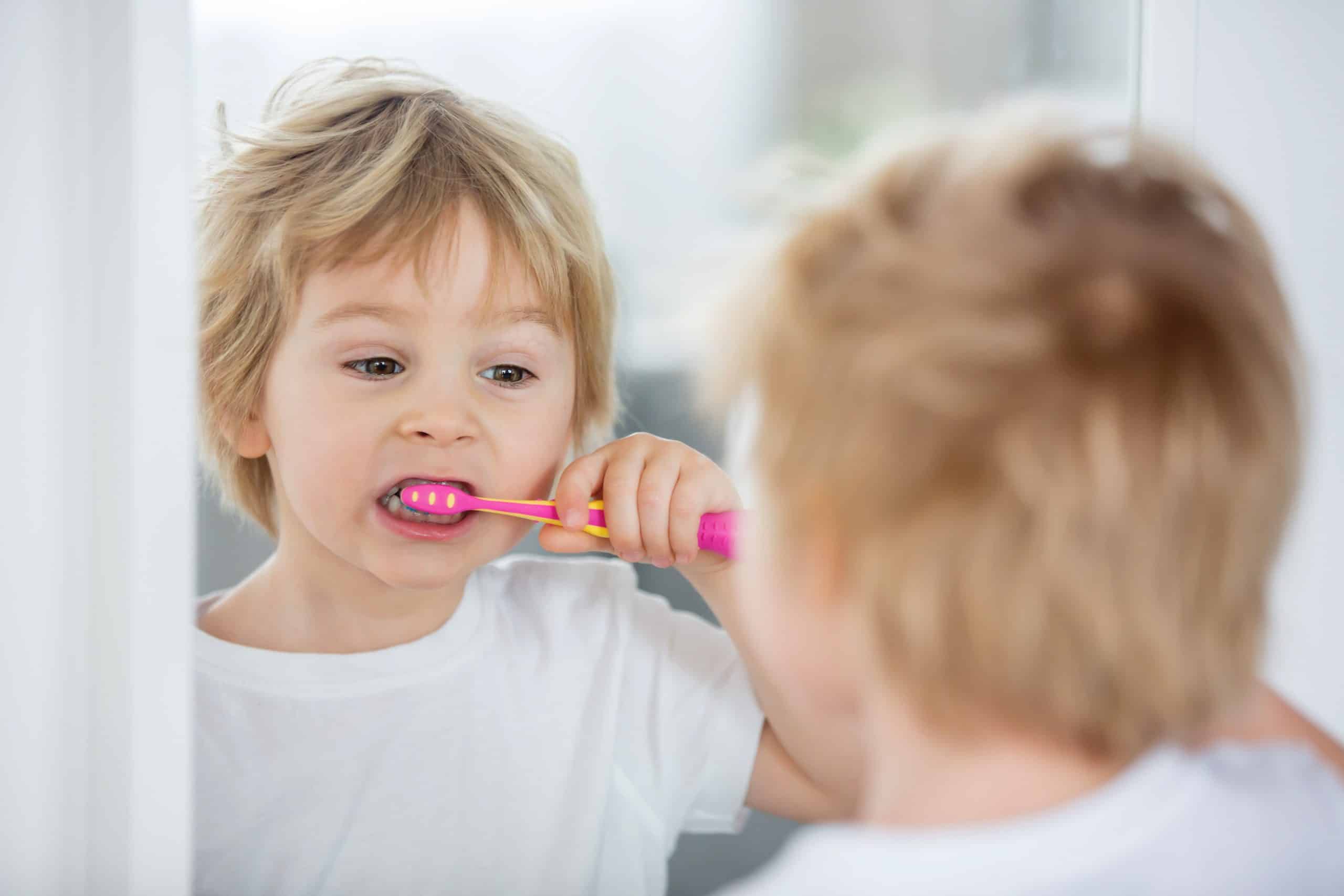 Dziecko myjące zęby manualną szczoteczką do zębów