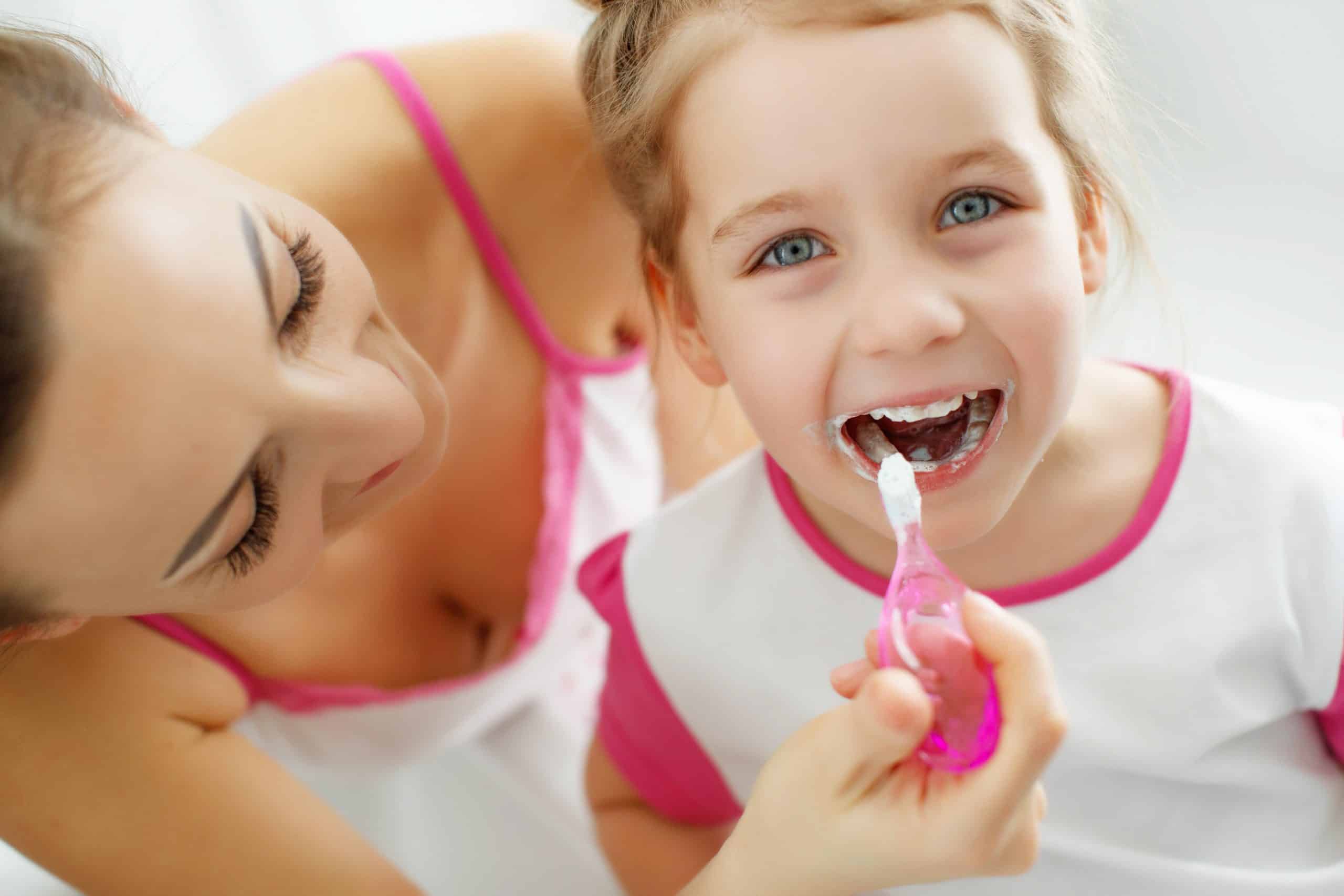 Mama myjąca zęby dziecku manualną szczoteczką dla dzieci