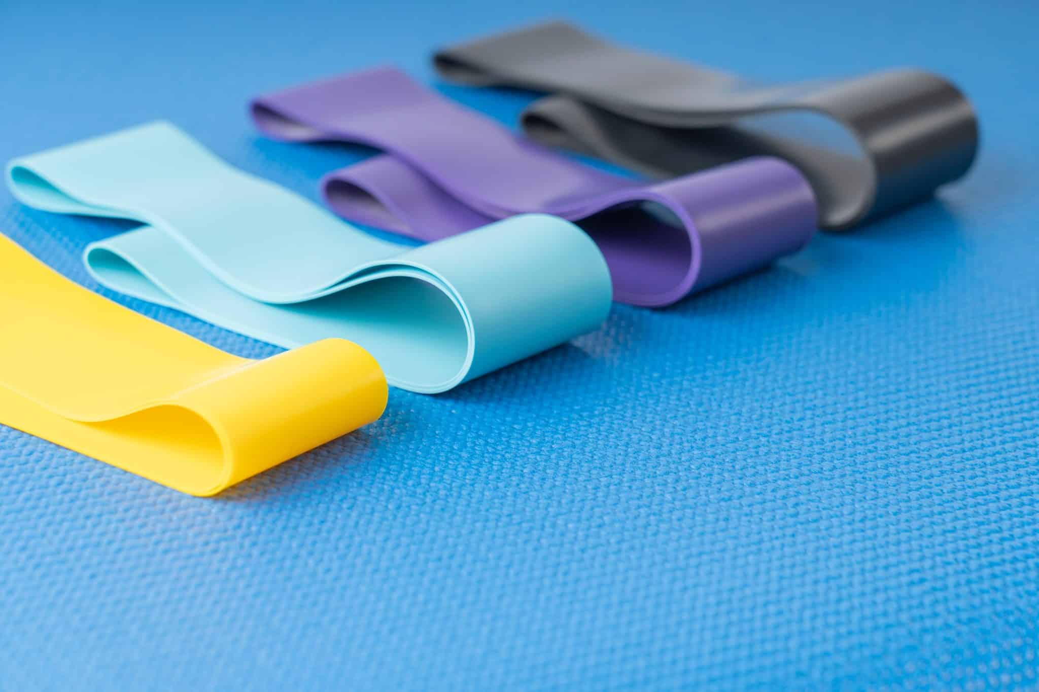 Zestaw kolorowych gum oporowych do ćwiczeń leżących na fitenssowej macie