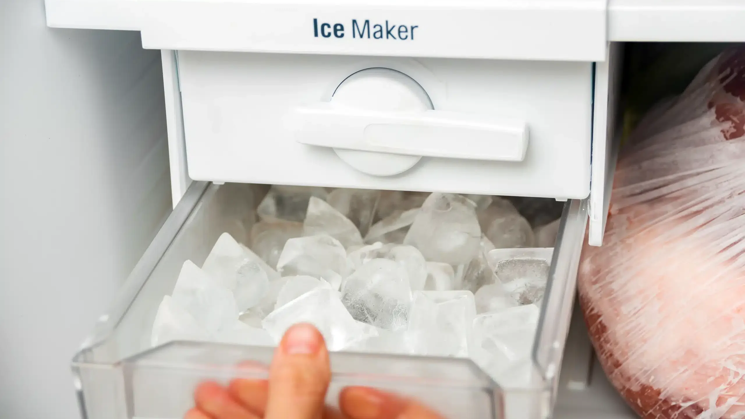 Wnętrze lodówki z kostkarką twistową pełną kostek lodu