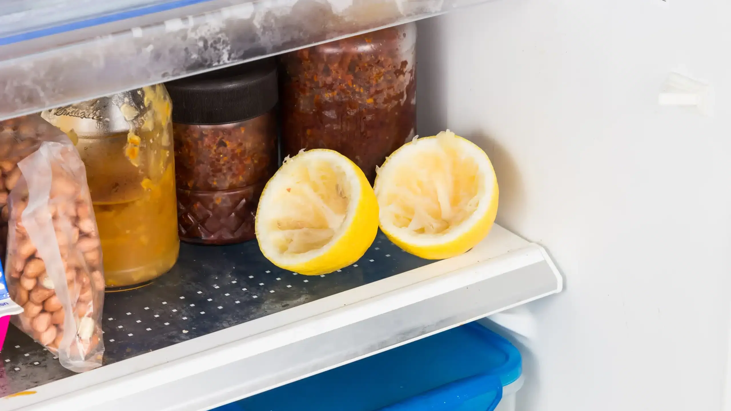 Połówki wyciśniętej cytryny ułożone na półce chłodziarki - domowy sposób na zapachy w lodówce