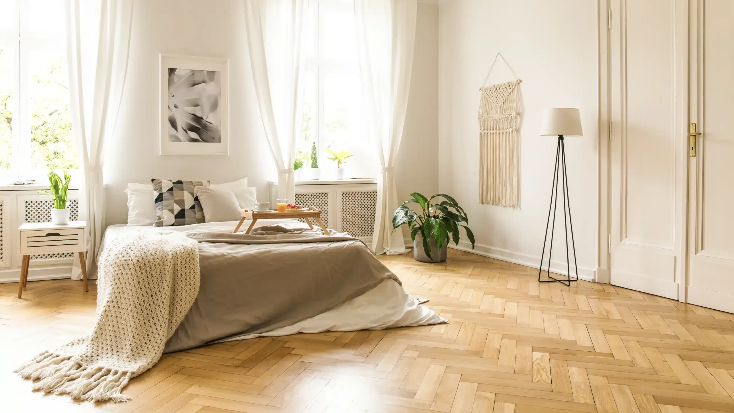 Sypialnia z łóżkiem i drewnianym parkietem umytym mopem elektrycznym do podłóg drewnianych