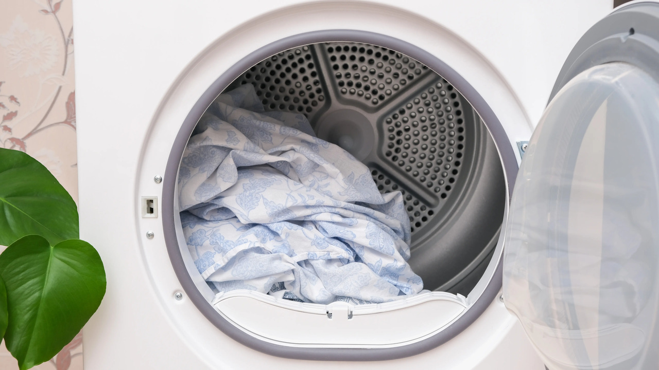 Bęben otwartej elektrycznej suszarki na pranie z umieszczonymi wewnątrz wysuszonymi tekstyliami