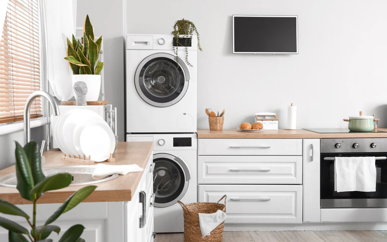 Elektryczna suszarka do suszenia ubrań w małym mieszkaniu ustawiona na pralce w nowoczesnym, jasnym pomieszczeniu