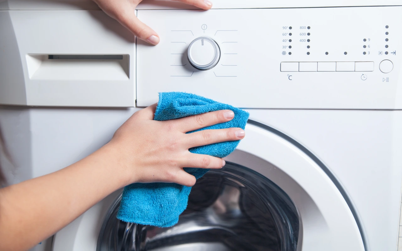 Czyszczenie pralki z zewnątrz wilgotną ściereczką z łagodnym detergentem do mycia pralki