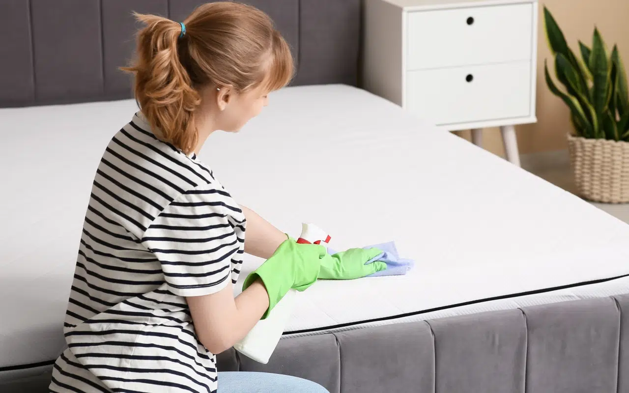 kobieta czyści materac płynem do prania tapicerki