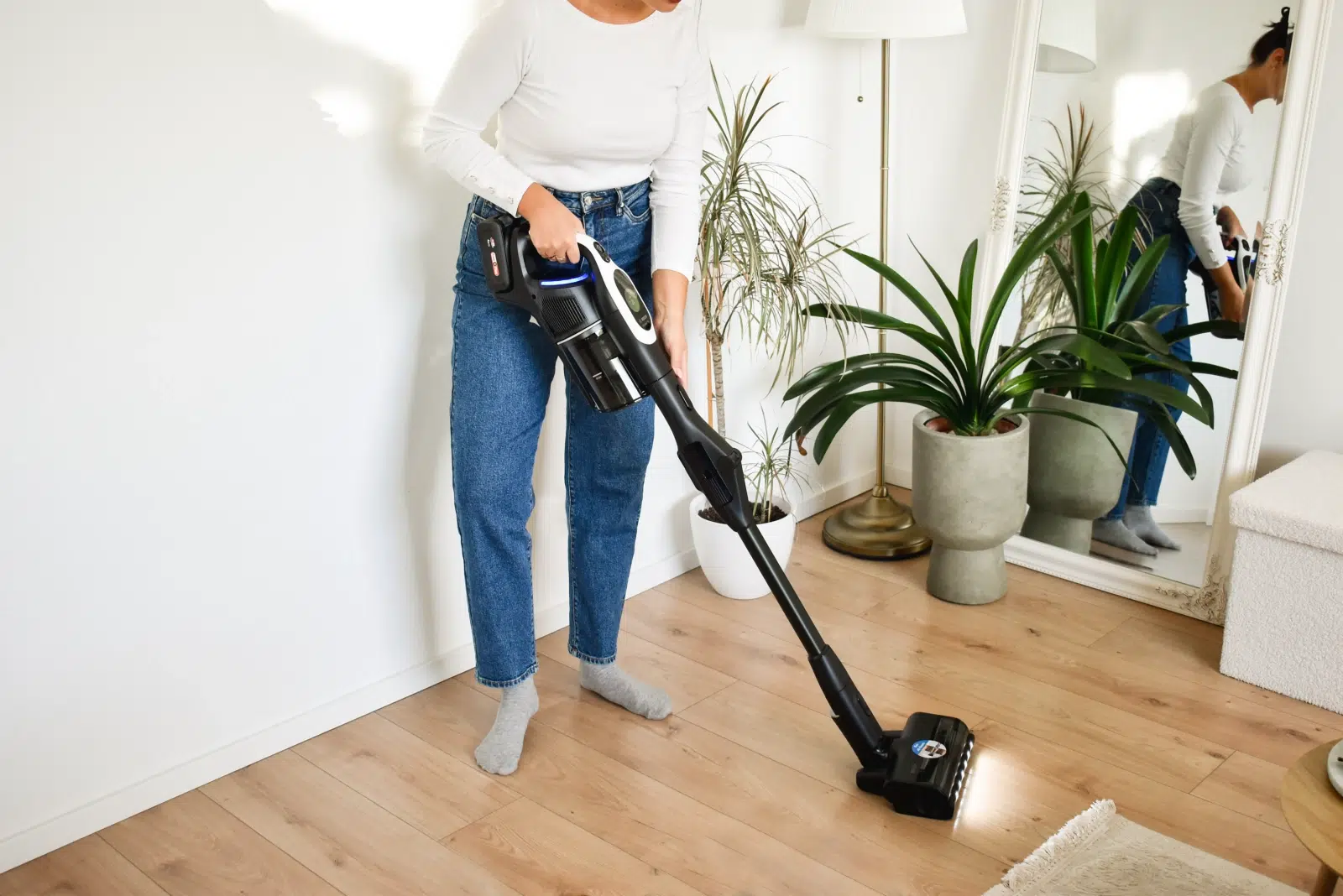 kobieta sprząta odkurzaczem pionowym Bosch Unlimited 10 BCS1041WAC w jasnym, nowoczesnym pomieszczeniu