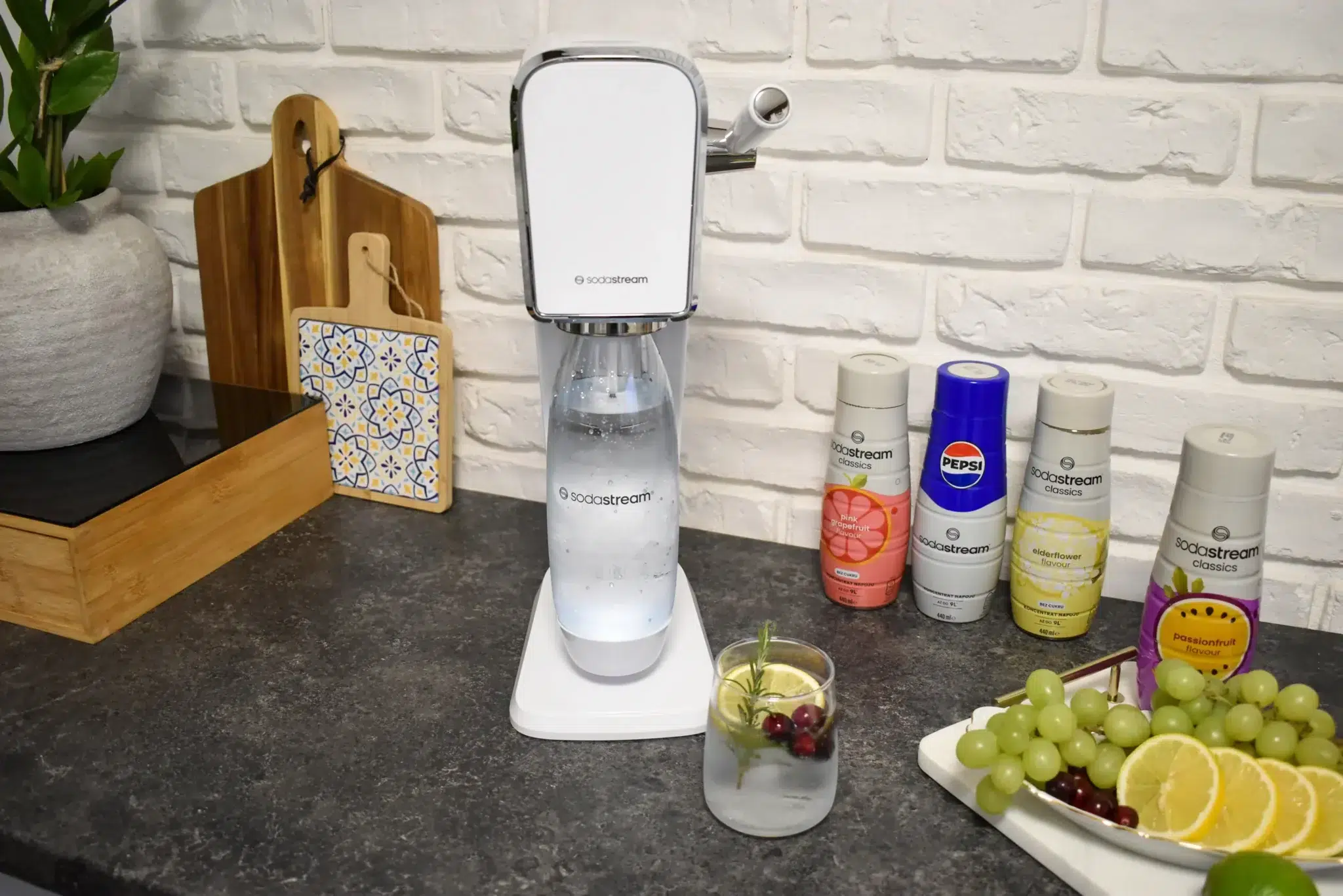 saturator do wody gazowanej SodaStream Art stoi na kuchennym blacie; obok syropy SodaStream