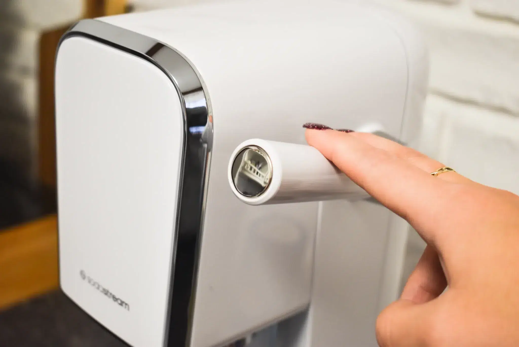 kobieca dłoń naciska dźwignię saturatora do gazowania wody SodaStream Art