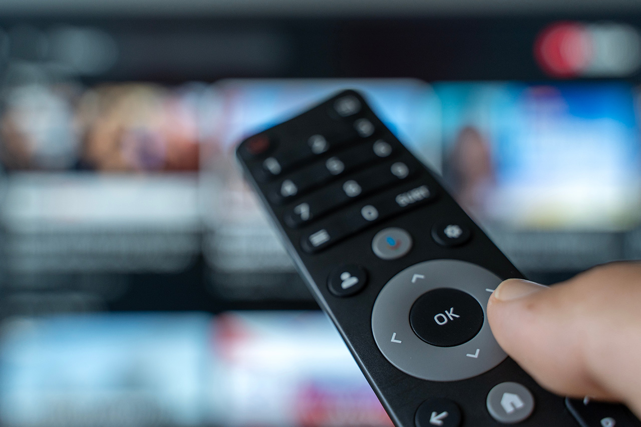 Pilot zbliżony do ekranu telewizora. - zdjęcie