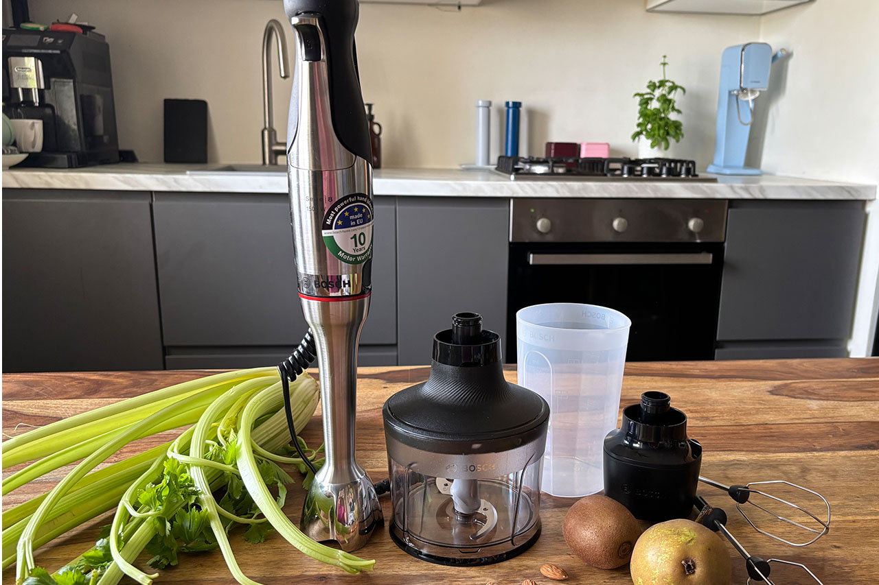 Blender ręczny Bosch Ergomaster z akcesoriami stoi na drewnianym blacie w kuchni. - zdjęcie