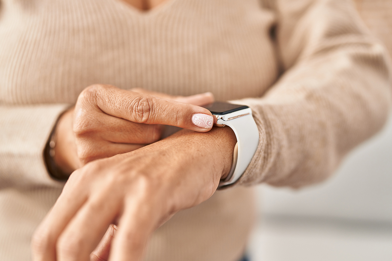 Kobieta próbująca włączyć smartwatch - zdjęcie