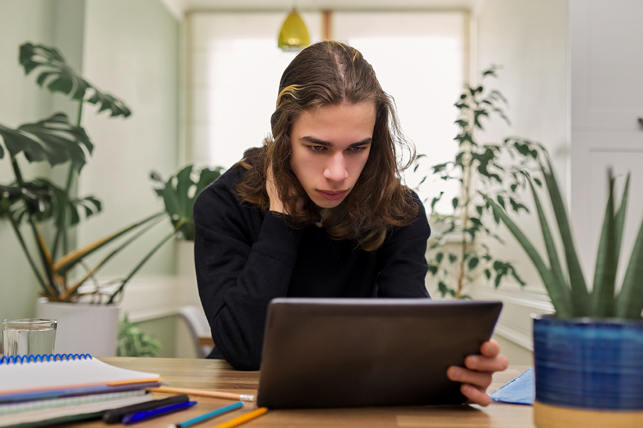 Student próbujący włączyć tablet - zdjęcie
